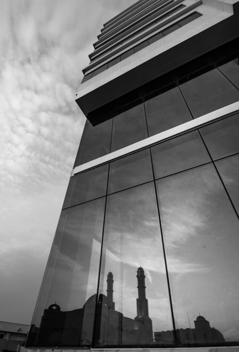 A buildings silhouette reflected in the glass facade of another building architecture photography composition