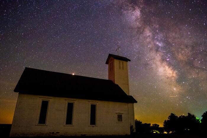 A church with the Milky Way in the night sky about it as an example of astrophotography