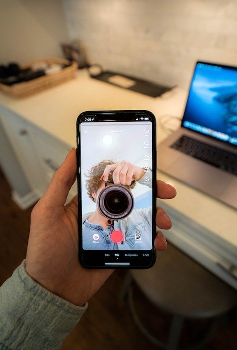 person taking a picture of their phone with camera app open
