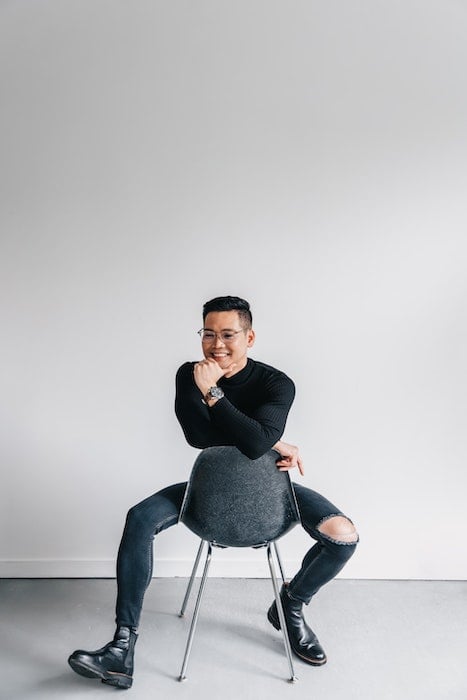 Man sitting on a backward chair as an example of male poses