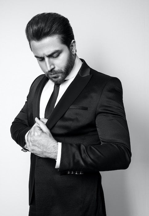 male pose of a man in suit going in pocket