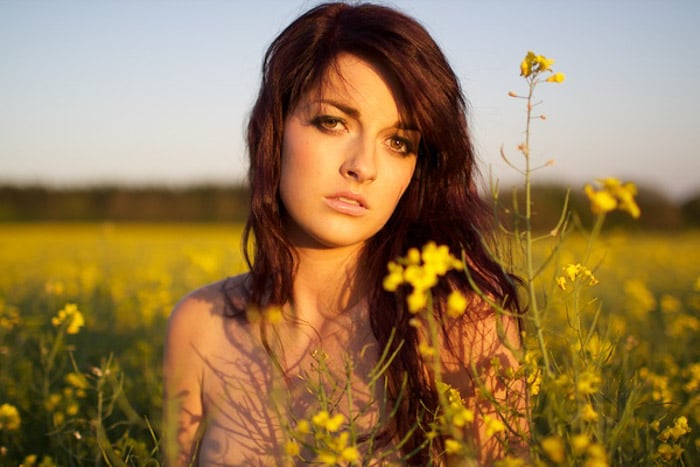 A female model posing outdoors in low light