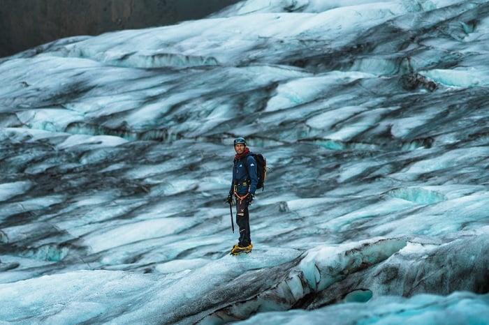 Man standing on ice glacier