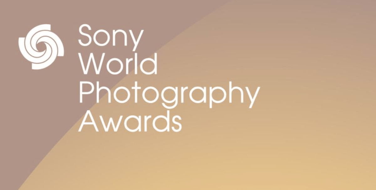 A promotional poster for the Sony World Photography Awards, which features a warm orange and gold color scheme. 
